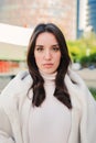 Vertical individual close up portrait of brunette teenage girl standing outdoors. Front view of serious young woman Royalty Free Stock Photo