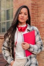 Vertical individual portrait of a pretty hispanic female student with serious expression looking at camera at high Royalty Free Stock Photo