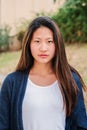 Vertical individual portrait of serious young woman standing outdoors. One pensive teen female student looking at camera Royalty Free Stock Photo