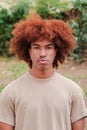 Vertical individual portrait of young african american man looking serious at camera. Teenage male with pensive attitude Royalty Free Stock Photo