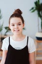 vertical indoor portrait of happy preteen girl posing in modern scandinavian interior