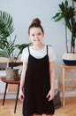 vertical indoor portrait of happy preteen girl posing in modern scandinavian interior, dressed in stylish black and white colors