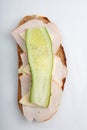 Vertical isolated close up top view shot of a single white bread turkey ham and cheese sandwich with a slice of cucumber on top on Royalty Free Stock Photo
