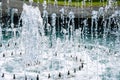 Vertical jets of fountain form circle. Turquoise water of pond as decoration of city park