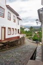 Vertical landscape with cobbled street, colonial houses and mountain in the background in Ouro Preto, Brazil