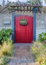 Vertical Landscaped garden with pathway inside white fence and red gate with pergola Royalty Free Stock Photo