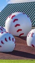 Vertical Large baseball decoration at a playground viewed on a sunny day