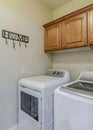 Vertical Laundry appliances inside small and functional utility room of residential home