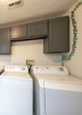 Vertical Laundry room exterior with laundry units and gray colored cabinets and drawers