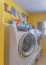 Vertical Laundry room interior with decorations on the yellow wall