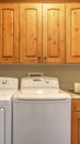Vertical Laundry room interior with washer dryer and counter against the beige wall