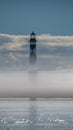 Vertical of a lighthouse surrounded by mist and water Royalty Free Stock Photo