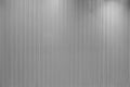 Vertical line textured grey wall with lights hitting it from different angles