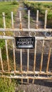 Vertical Locked rusty old gate with private property sign and view of lake and mountain