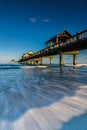 Vertical long exposure of a pier at the shore