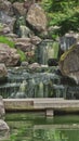 Vertical long exposure shot of a beautiful waterfall in Japanese garden Royalty Free Stock Photo