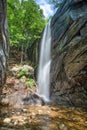 Vertical long exposure shot of a small waterfall in a park