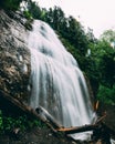 Vertical long exposure of a waterfall flowing down the cliff into a river in a nature park Royalty Free Stock Photo