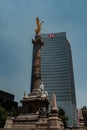 Vertical low-angle of Angel of Independence monument with HSBC building in the backdrop