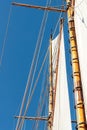 Vertical low angle closeup shot of the sails of a schooner on blue background Royalty Free Stock Photo