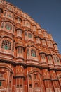 Vertical, low-angle of an exterior of The Hawa Mahal palace in Jaipur, India, with a blue sky above