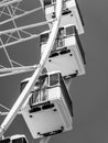 Vertical low-angle grayscale view of the Ferris wheel cabins
