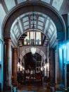 Vertical low angle shot of the arch-shaped hallway of a building with a nice pendant lamp Royalty Free Stock Photo