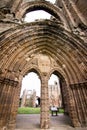 Vertical low angle shot of the beautiful arch-shaped entrance of Elgin Cathedral in Elgin, UK