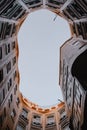 Vertical low angle shot of a blue sky through a rounded building in Barcelona, Spain