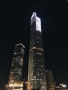 Vertical low angle shot of a city with high rise buildings bursting light during nighttime