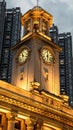 Vertical low angle shot of a city skyline with an illuminated gold clock tower in Wuhan Royalty Free Stock Photo