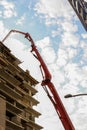 Vertical low angle shot of a crane near a building under construction Royalty Free Stock Photo