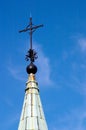 Vertical low angle shot of a cross on top of a church under a clear blue sky Royalty Free Stock Photo