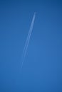 Vertical low angle shot of jet trails on the blue sky Royalty Free Stock Photo