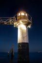 Vertical low angle shot of a lighthouse captured by the ocean under the starry sky Royalty Free Stock Photo