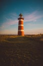 Vertical low angle shot of a lighthouse in a grassy field Royalty Free Stock Photo