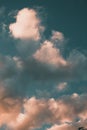 Vertical low angle shot of the magnificent fluffy clouds in the blue sky