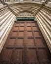 Vertical low angle shot of a magnificent old wooden door with a beautiful stone frame Royalty Free Stock Photo