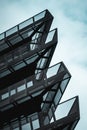 Vertical low angle shot of a modern office building against the blue sky Royalty Free Stock Photo