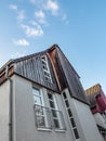 Vertical low angle shot of an modern wooden house against a blue sky Royalty Free Stock Photo