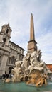 A vertical low angle shot of the Obelisco Agonale fountain with sculptures at at Piazza Navona