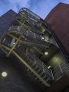 Vertical low angle shot of an outdoor escape staircase of a building at night Royalty Free Stock Photo