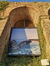 Vertical low-angle shot of a picture of a violin grif hanging on a building arch