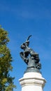 Vertical low-angle shot of a statue of a fallen angel in the Retiro Park, Madrid, Spain