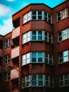 Vertical  low angle shot of a stone building facade with windows and balconies Royalty Free Stock Photo