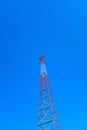 Vertical low angle shot of a tall radio tower under a clear blue beautiful sky Royalty Free Stock Photo