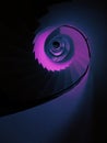 Vertical low angle shot of a tall spiraling staircase in aesthetic purple color Royalty Free Stock Photo