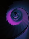 Vertical low angle shot of a tall spiraling staircase in aesthetic purple color Royalty Free Stock Photo