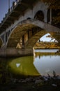 Vertical low angle shot of the understructure and pillars of a bridge captured on a sunny day