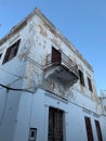 Vertical low angle shot of weathered medieval house under blue sky in Rhodes Old Town, Greece